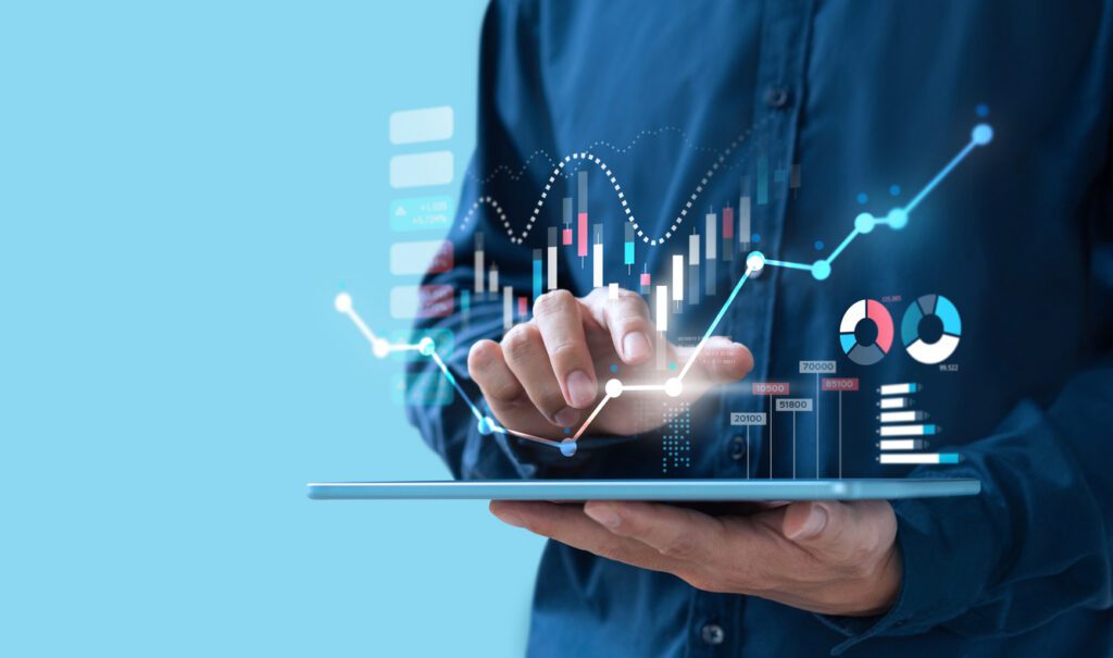 Man interacting with futuristic financial data charts on a tablet, showing growth and analysis.